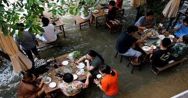 High tide in a river in Thailand converts a restaurant for a tourist interface instead of closing photos