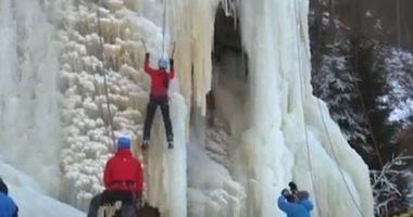 Athletes compete for climbing a huge rock summit covered by snow in Czech